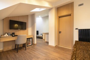 A modern room with a wooden desk, a mounted TV, a chair, and a door. - Megasaray Mount Erciyes (Kayseri)
