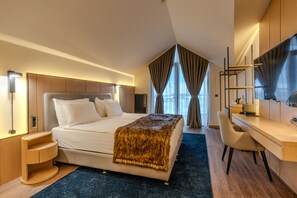 A modern hotel room with a large bed, a desk, and a chair. - Megasaray Mount Erciyes (Kayseri)