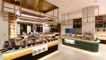 A modern buffet setup with multiple food stations, including a variety of dishes and beverages.