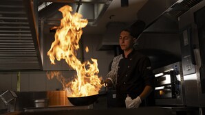 A chef performing a flambé with a flaming pan in a professional kitchen. - Megasaray Mount Erciyes (Kayseri)