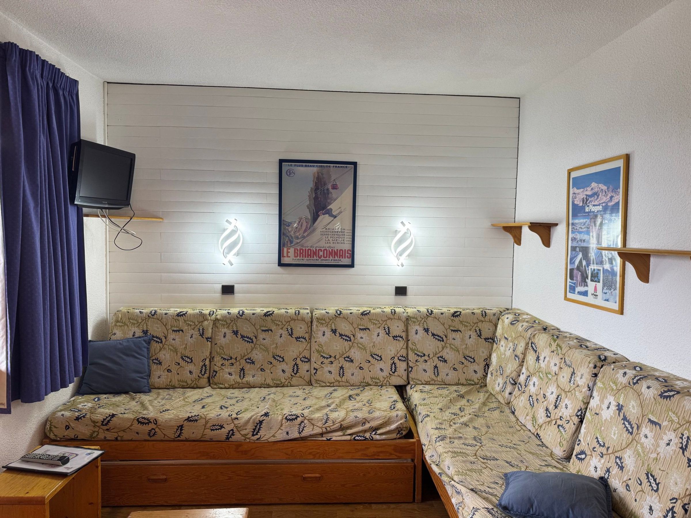 Ein Zimmer mit Schlafsessel, Fernseher und einem Bild an der Wand.