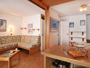 Ein gemütliches Wohnzimmer mit einer Couch, einem Couchtisch und einem Essbereich mit Tisch und Stühlen.