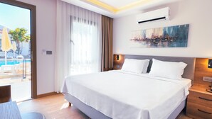 Une chambre d’hôtel moderne avec un grand lit, un bureau et une vue sur une piscine et un immeuble.