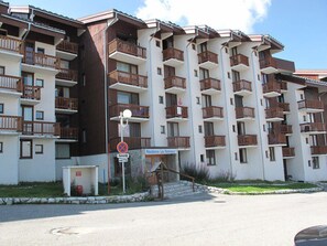 A multi-story hotel with balconies, a no parking sign, and a sign indicating "Résidence Les Hameaux 1".