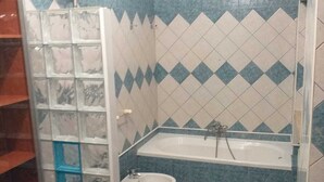 A bathroom with a bathtub, a toilet, and a bidet. - Cottage 30 steps from the sea (Fiumicino)