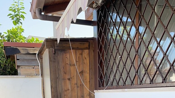 A patio area with wicker furniture and a stone floor. - Cottage 30 steps from the sea (Fiumicino)