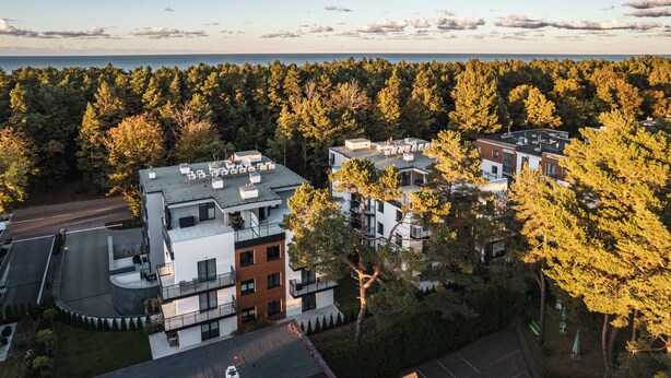 A modern residential building with multiple floors, large windows, and a flat roof. - Apartamenty Sun & Snow Double Rest (Wladyslawowo)