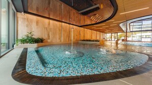 An indoor swimming pool with a tiled floor, wooden walls, and a clear view of the outside. - Prywatne Apartamenty Sun & Snow w Wave (Miedzyzdroje)