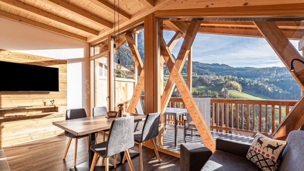 A wooden interior with a dining area, a sofa, and a TV. - Holiday Apartment "Zu Grof Morgenrot" (Castelrotto)