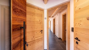 A hallway with wooden doors and a tiled floor. - Holiday Apartment "Zu Grof Morgenrot" (Castelrotto)