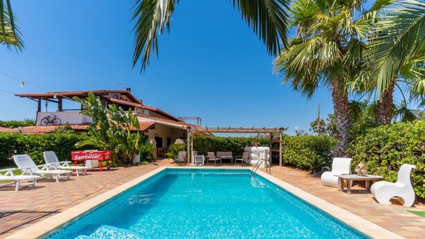 A swimming pool with lounge chairs, a pergola, and a house in the background. - Holiday Home 'Villa Relax Due' with Shared Pool & Wi-Fi (Galatone)