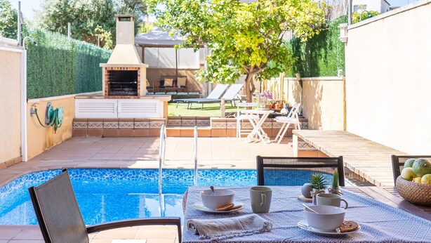 Un pati amb piscina, mobiliari d'exterior i zona de barbacoa.
