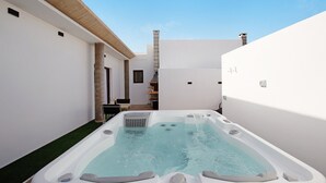 A hot tub in a narrow outdoor space with white walls and a wooden roof. - Holiday Apartment "Crepusculo" with Mountain View, Terrace & Wi-Fi (Puerto del Rosario)