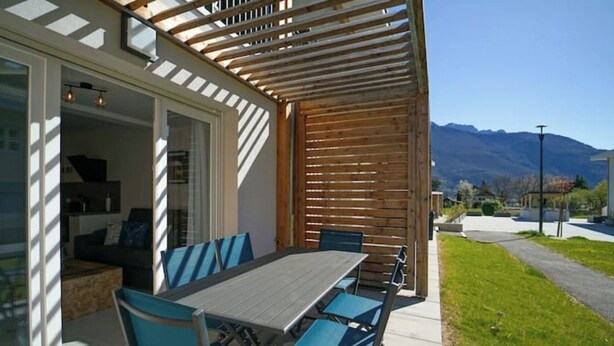 A covered patio with a table and chairs, a wooden pergola, and a view of mountains. - The Family Lake - Appartement 2 Chambre, Terrasse & Parking (Lathuile)