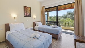 A hotel room with two beds, a balcony with a table, and a painting on the wall.