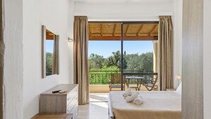 Une chambre à coucher comprenant un lit, un bureau, une chaise et un balcon avec une table et des chaises.