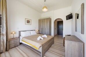 Une chambre d’hôtel comprenant un lit, des tables de chevet, une télévision, une armoire et un miroir.
