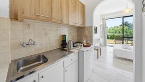 Una cocina moderna con armarios de madera, un lavamanos de acero inoxidable y un comedor con mesa y sillas.