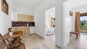 Una cucina moderna con mobili in legno, un tavolo da pranzo e sedie. Si trova anche una camera da letto con un letto e un balcone con vista.