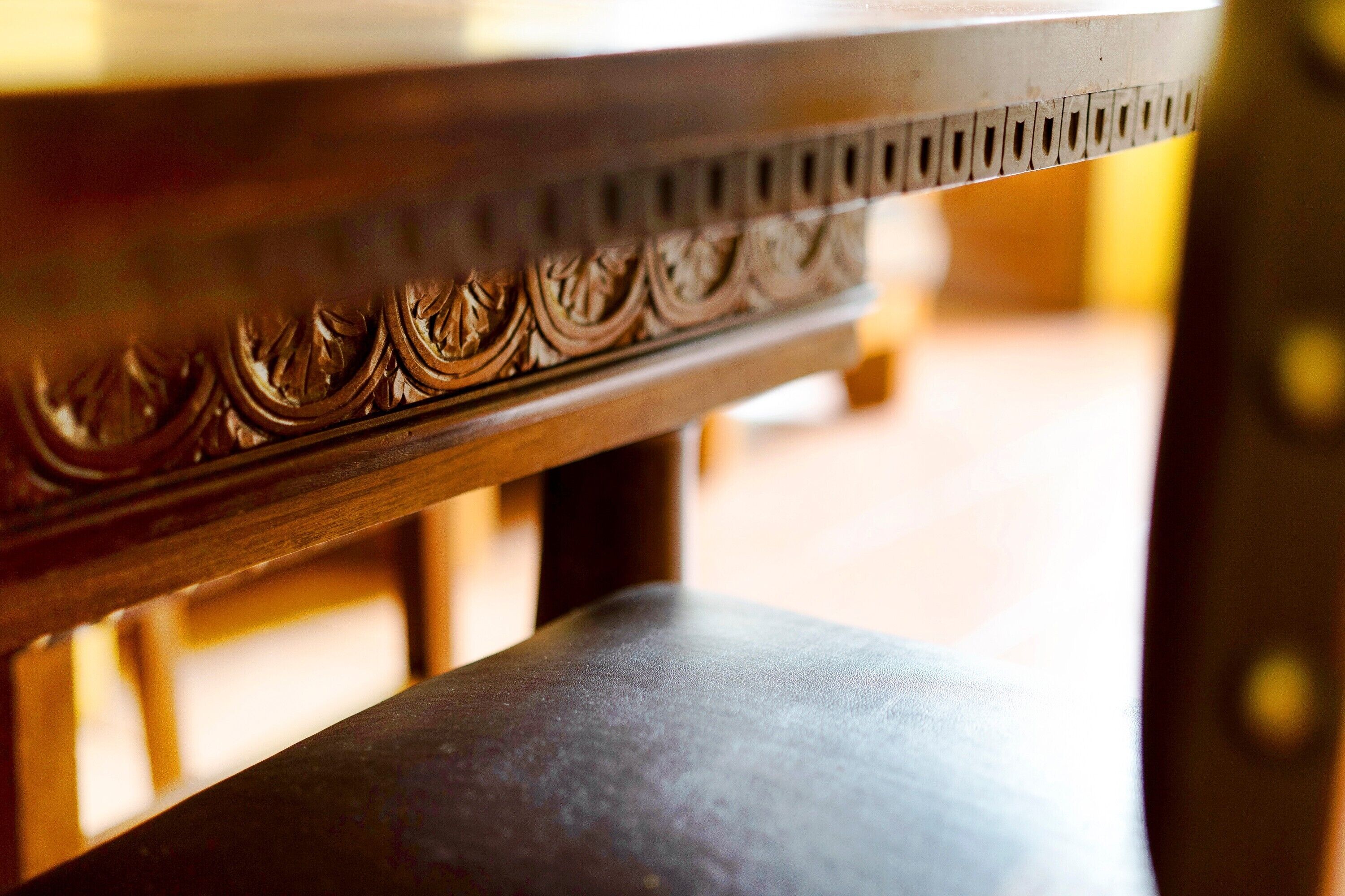 A close-up of a wooden table with intricate carvings.
