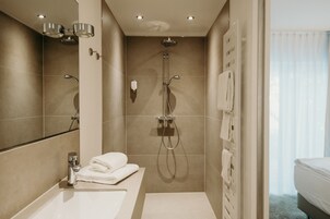 Un baño moderno con bañera, ducha y lavabo.
