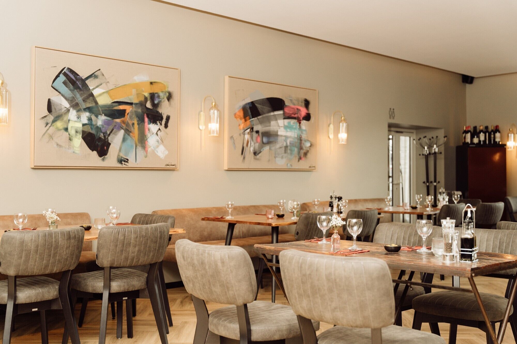 A restaurant with modern decor, abstract art on the walls, and a variety of seating options.
