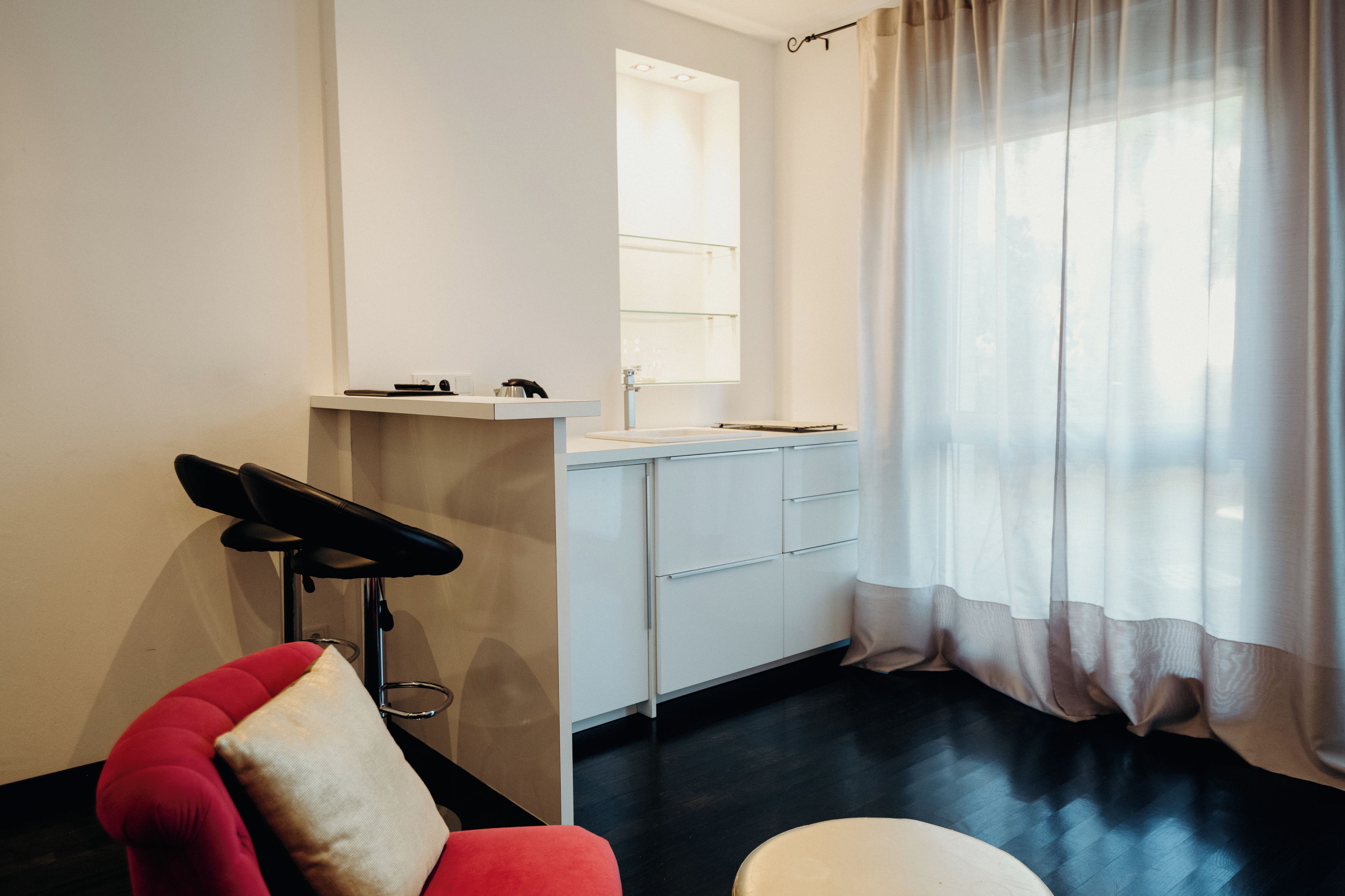 Un baño moderno con espejo, lavabo y una silla.