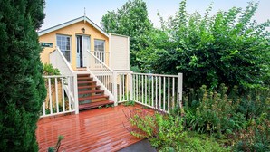 A two-story house with a wooden deck and white railings.