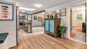 Une cuisine moderne avec un coin repas, des meubles en bois et une vue sur le salon.