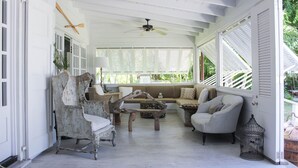A room with a ceiling fan, a wooden coffee table, and a sofa with cushions. - Luxury Holiday Estate with Pool, minutes walk from Pink Sands beach (Harbour Island)