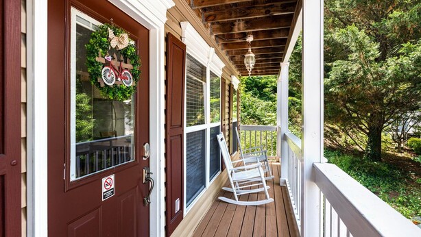 A wooden porch with a white railing, a rocking chair, and a door with a 'No Smoking' sign. - Piper's Landing: Touch Down in the Smokies (Gatlinburg)