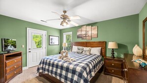 A bedroom with a large bed, a ceiling fan, a television, and a dresser. - Piper's Landing: Touch Down in the Smokies (Gatlinburg)