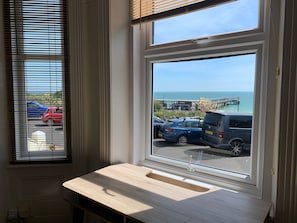 A room with a large window overlooking a parking area and a pier.