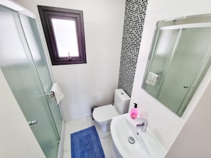 A bathroom with a toilet, sink, and a window. - Happy Homes Paradise (Larnaca)