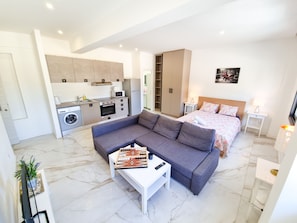 A modern apartment with a living area, kitchenette, and bedroom. - Happy Homes Paradise (Larnaca)