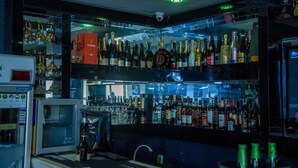A bar area with multiple shelves of liquor bottles and glasses. - Kelin Hotel & Suite (Lagos)