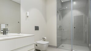 A modern bathroom with a glass-enclosed shower, a white sink, and a toilet. - The Axis 212 (Cape Town)
