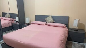 Ein Schlafzimmer mit einem großen Bett, zwei Nachttischen und einem Spiegel.