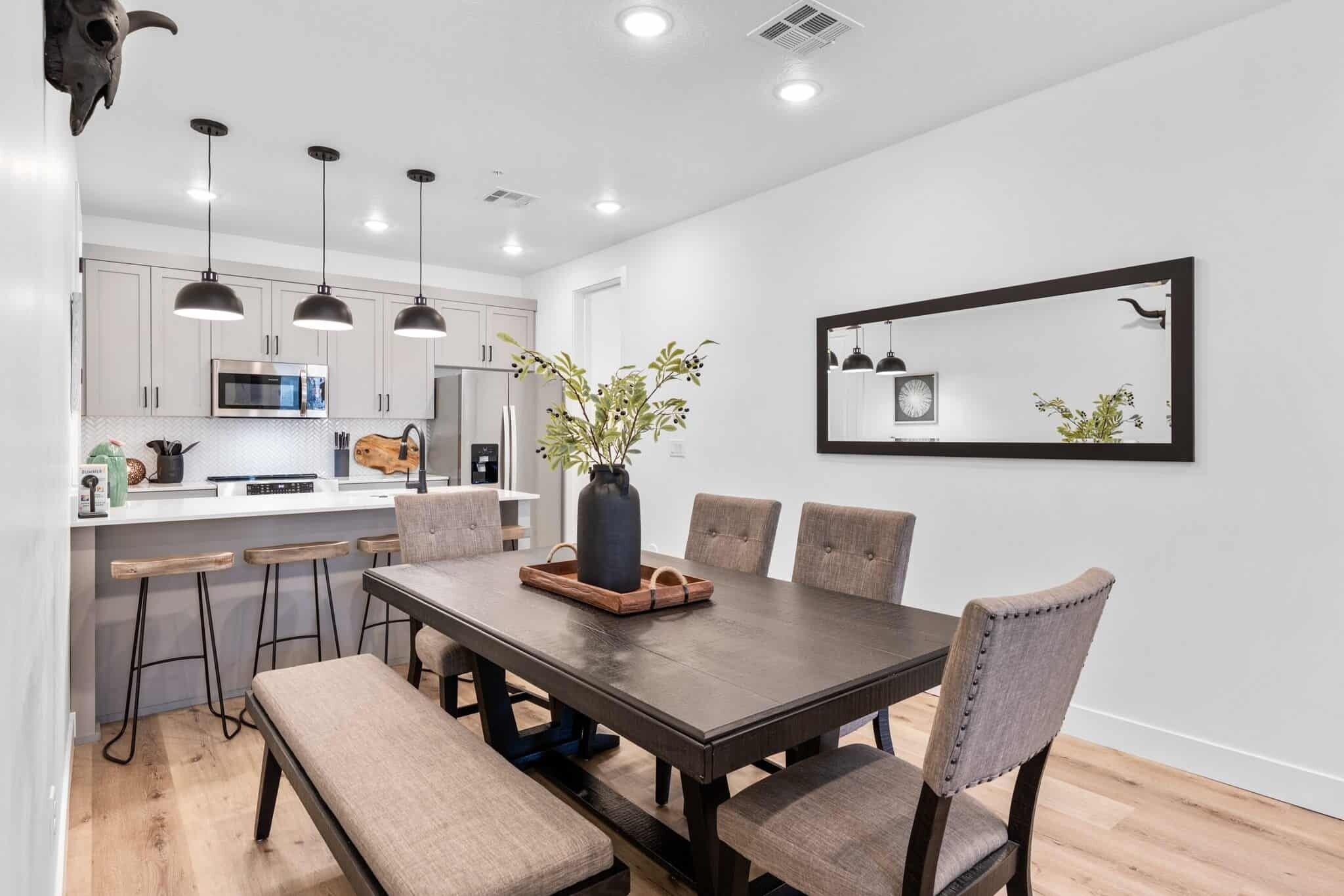 A modern kitchen with white cabinets, a central island, and pendant lighting.