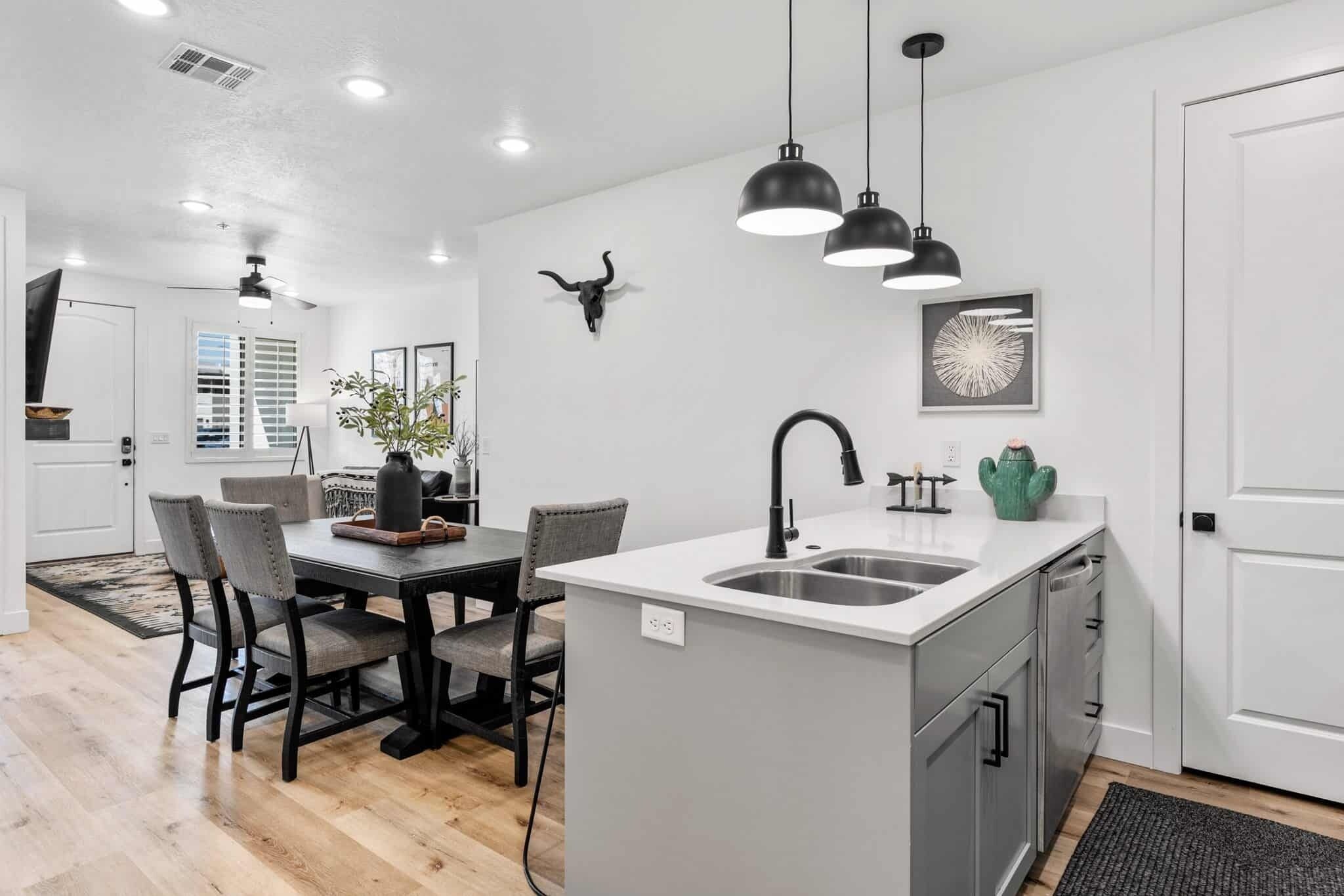 A modern kitchen with a central island, pendant lights, and a bull skull decoration.