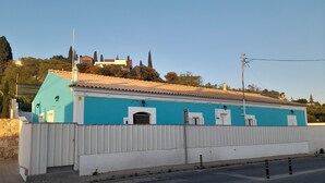 Ein Gebäude mit blauer Fassade, weißem Zierdekor und einem Ziegeldach.