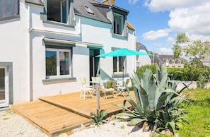 A two-story house with a wooden deck, outdoor seating, and a large aloe plant. - Holidays for 6 at the gates of Guilvinec. (Plomeur)