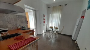 Une cuisine moderne avec un plan de travail en bois, une table à manger avec des chaises et un réfrigérateur.