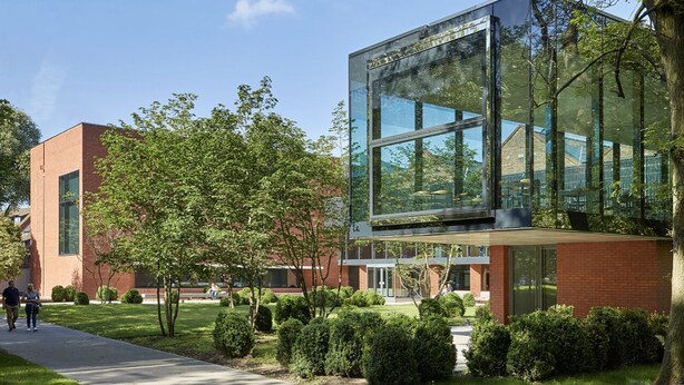 A modern building with large glass windows, surrounded by well-maintained greenery and a clear sky. - Private Studio Flat Great Location in Manchester (Manchester)