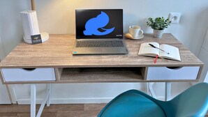 A wooden desk with a laptop, a lamp, a cup, a plant, and a notebook. - Apart'Moment SMART - Le Nid Douillet (Bourbourg)