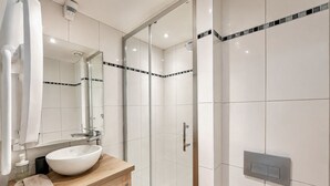 A modern bathroom with a large mirror, a sink, and a shower area. - Apart'Moment SMART - Le Nid Douillet (Bourbourg)