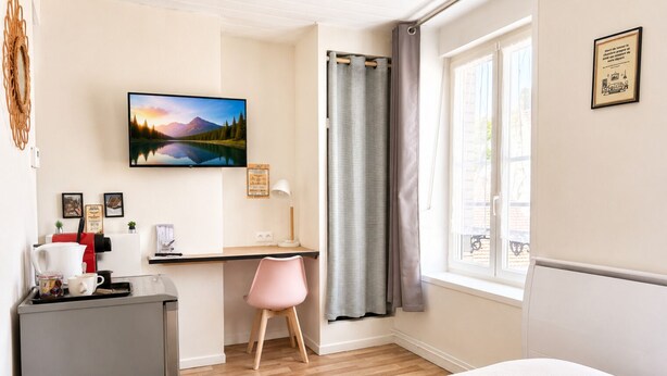 A hotel room with a bed, a desk with a computer, a coffee machine, a chair, and a window with curtains. - Apart'Moment SMART - Le Nid Douillet (Bourbourg)