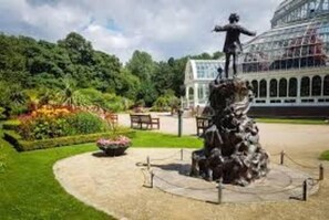 A statue in a garden with a building in the background. - Remarkable 2-bed Apartment in Leafy Sefton Park (Liverpool)