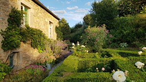 A stone building with a garden featuring neatly trimmed hedges and blooming white roses. - Le Moulin de Resteigne (Tellin)
