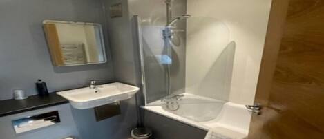 A modern bathroom with a sink, toilet, and shower.